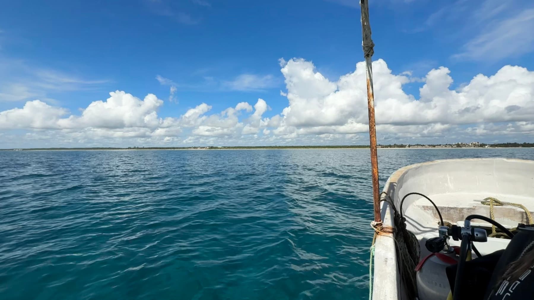 The bow of a dive boat on flat turquoise water
